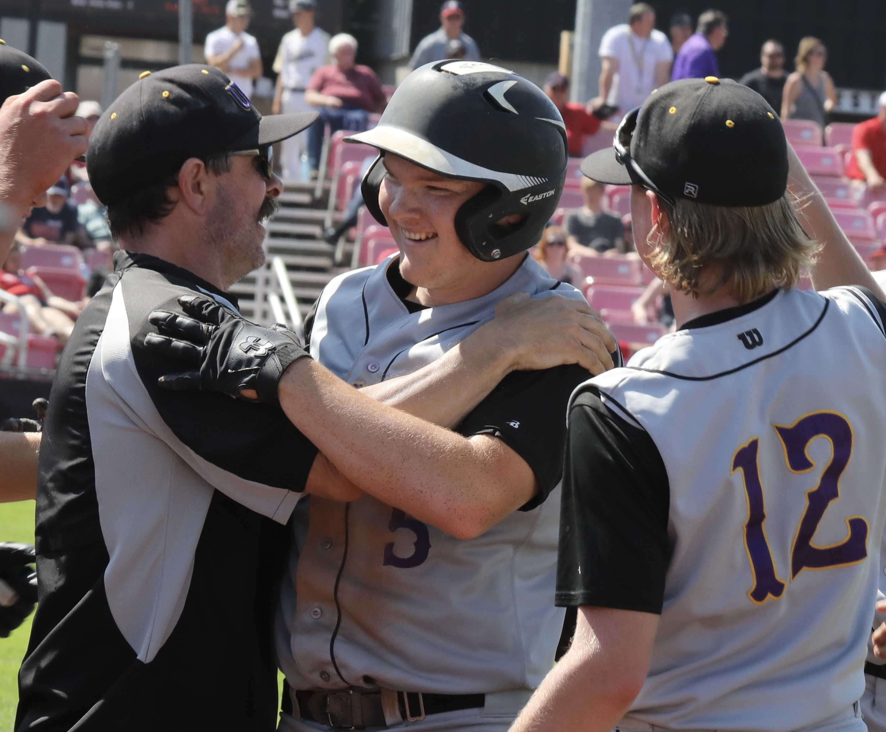 Umpqua Valley Christian's Isaiah Heard gets the cheers of a Monarch coach and teammate Jacob Luther after key two-run double