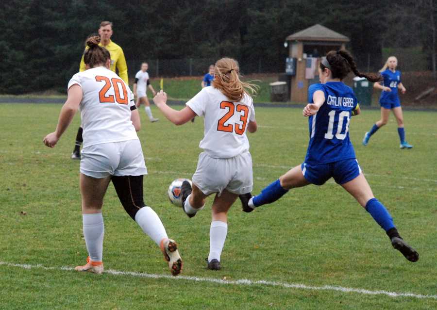 Ann Louise Naito (10) works to poke a pass past Yamhill-Carlton players Julie Easton (23) and Lisie Luttrell