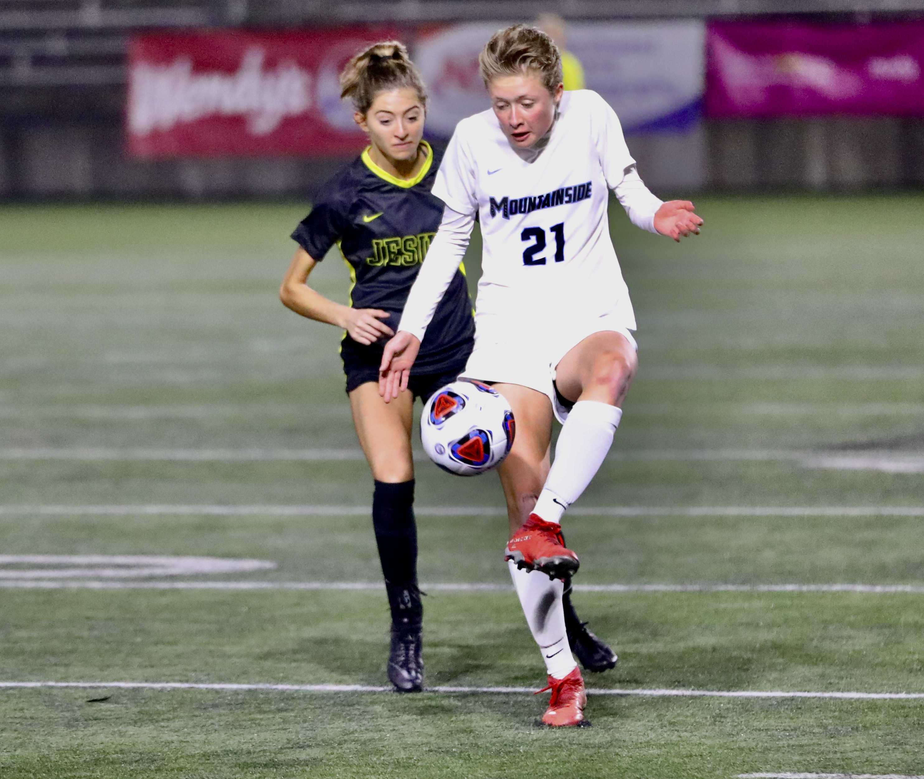 Mountainside forward Nina Rhode (21) and Jesuit defender Ella Nelson battle for a ball on the sideline (Photo by Norm Maves Jr.)