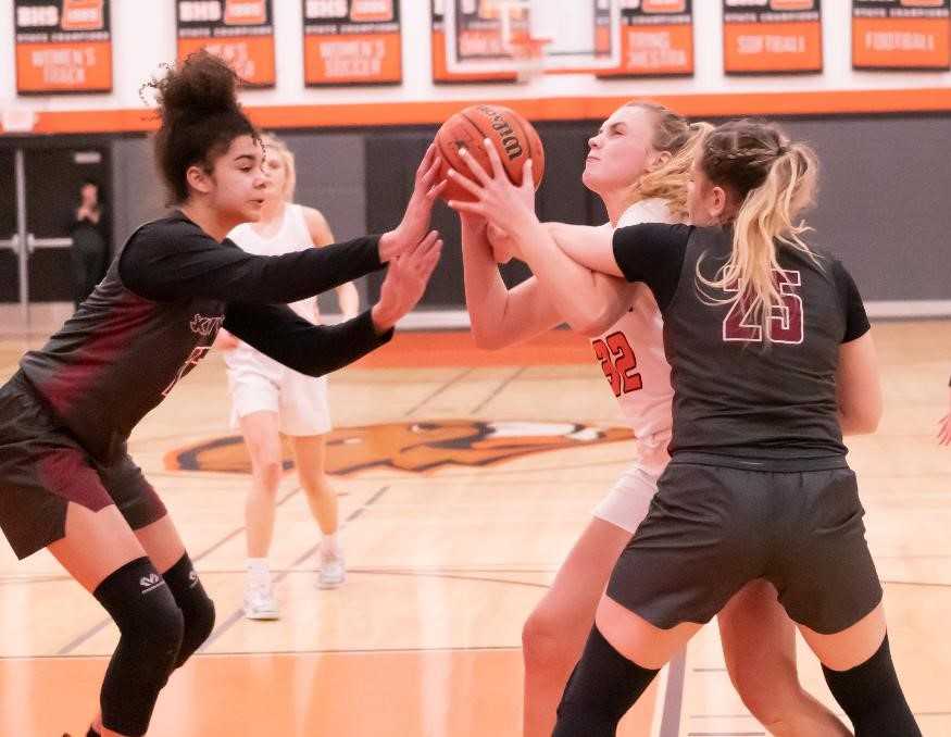 Beaverton's Sydney Erikstrup squeezes between Southridge's Tait Quinlan (left) and Kaylen Blair. (Photo by Gene Schwartz)