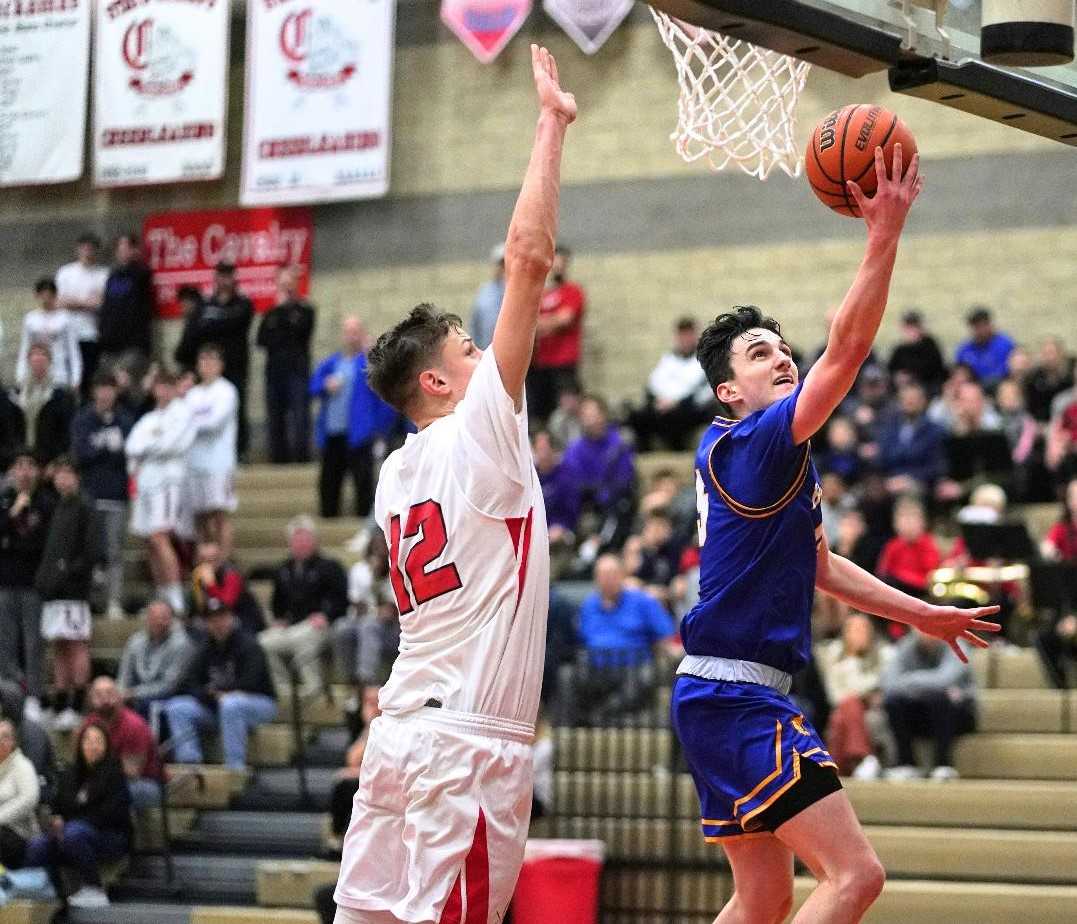 Barlow's Jesse White drives to the basket against Clackamas' Ben Gregg on Tuesday night. (Photo by Jon Olson)
