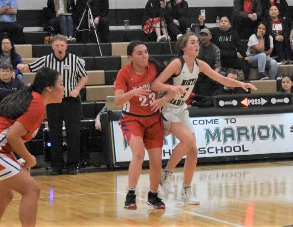 North Marion's Jaydan Sahlin (right) and Madras' DaRia White (23) battle for position. (Photo by Jeremy McDonald)