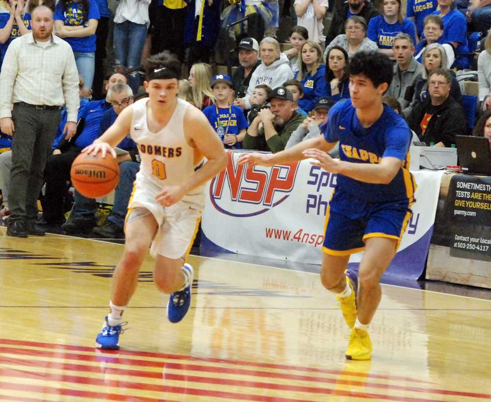 Toledo point guard Conner Marchant (0) dribbles past Knappa guard Kanai Phillip. Marchant scored 28 in the Boomer win
