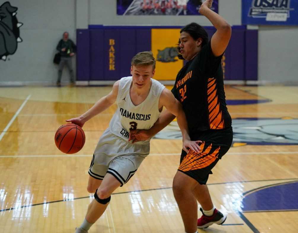 Damascus Christian's Spencer Powers drives against Nixyaawii's Magi Moses. (Randy Seals/Eastern Oregon Sports Photos)