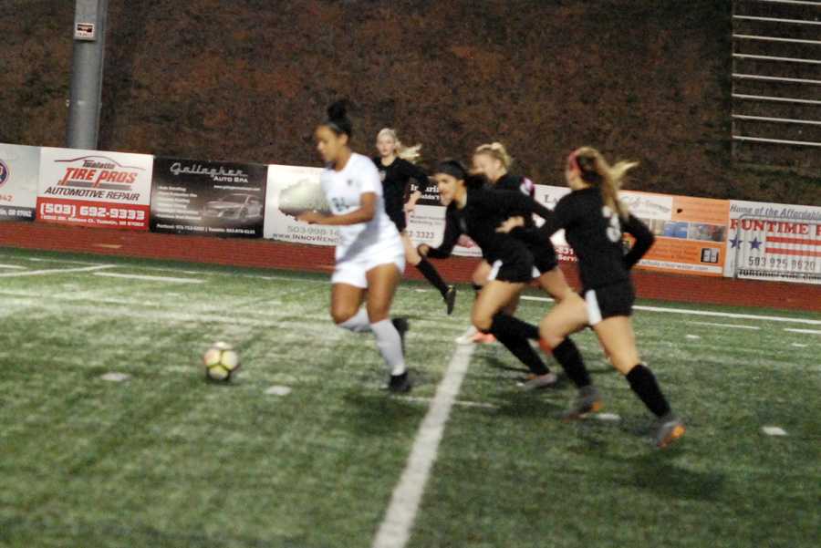 Gabi Brown (21) eludes a cadre of Tualatin defenders. Seconds later, she sent a screamer into the net for a 1-0 lead