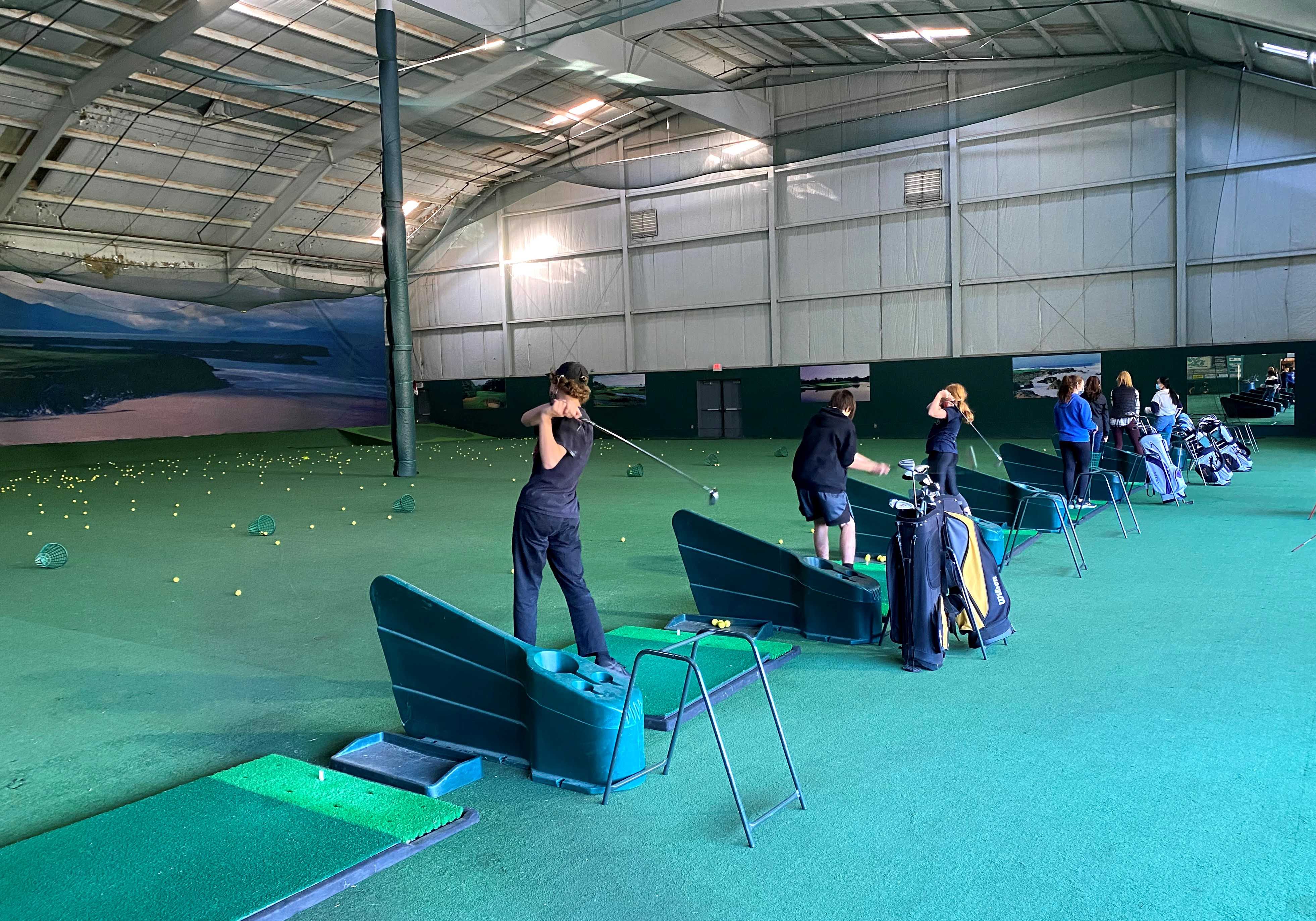 Students practice at the indoor driving range at Chinook Winds Golf Resort on Wednesday in Lincoln City.