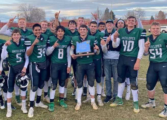 Quarterback Conley Martin (center) and Adrian celebrate a repeat 1A title on Saturday at Baker City.