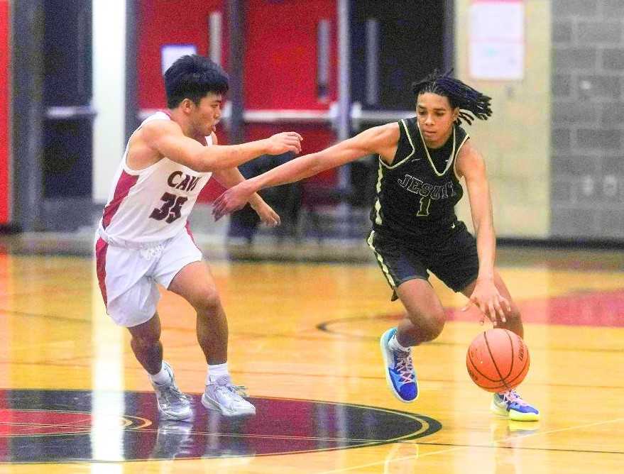 Jesuit's Isaiah Crane brings the ball up the court against pressure from Clackamas' Forrest Reyes. (Photo by Jon Olson)