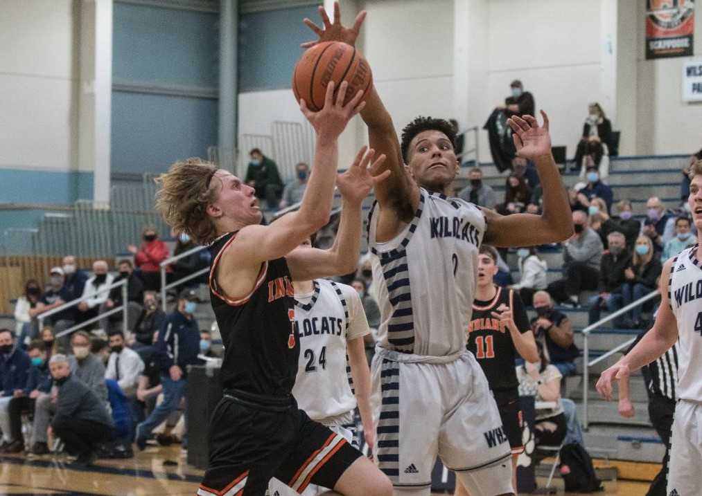 Scappoose's Colin Stoddard drives to the basket against Wilsonville's Tristan Davis on Tuesday night. (Photo by Greg Artman)
