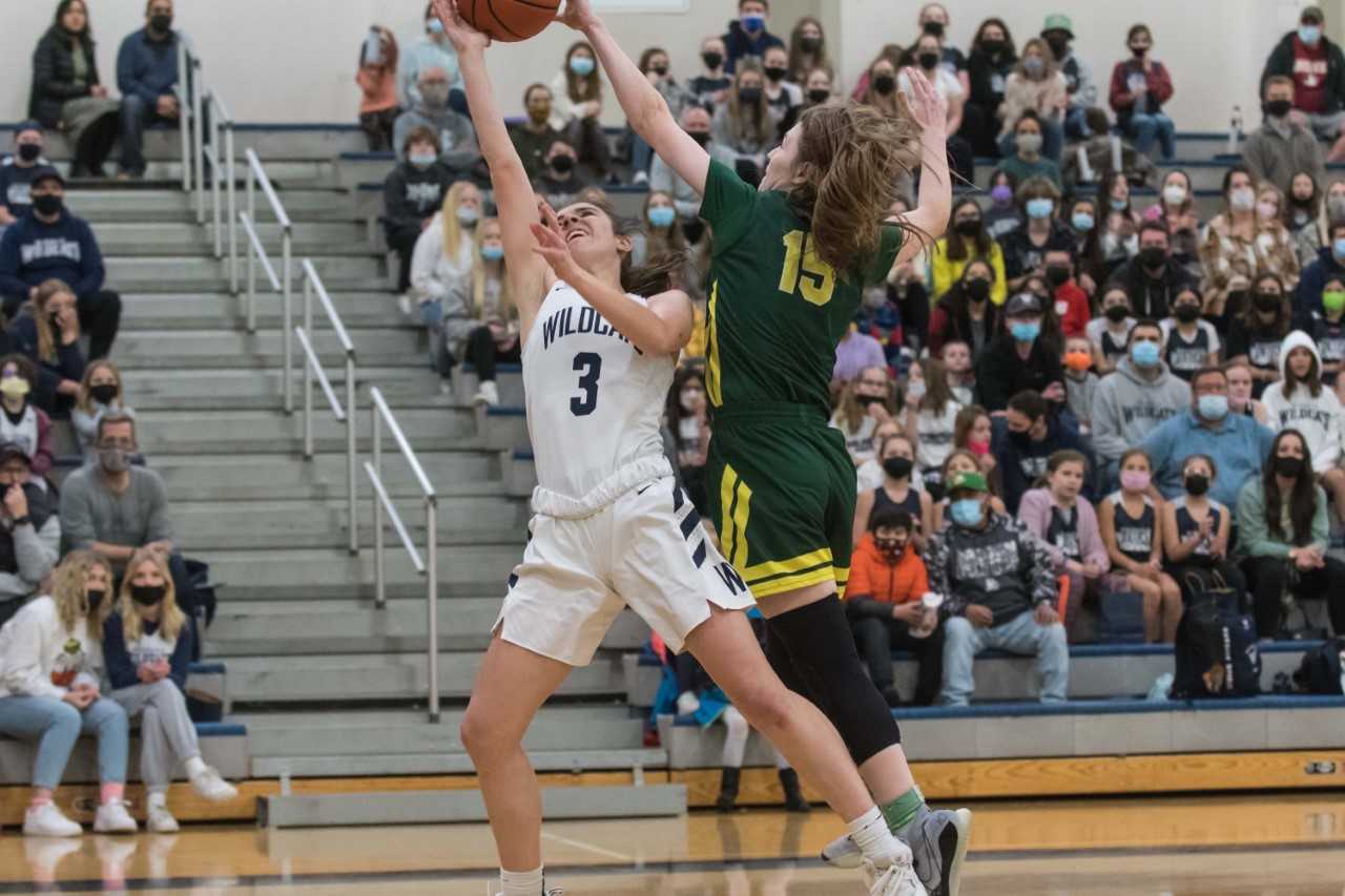 Wilsonville's Karina Borgen drives to the basket against Putnam's Maddie Olma on Thursday night. (Photo by Greg Artman)