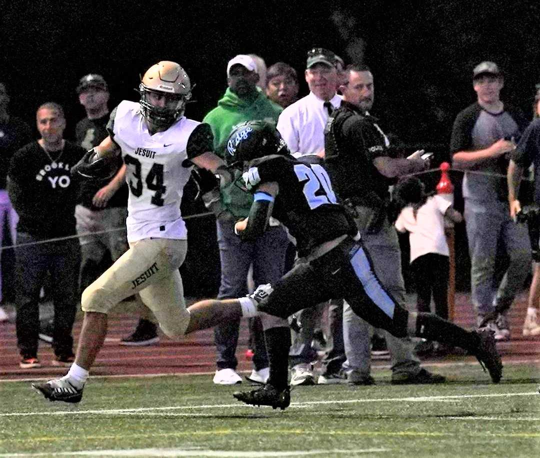 Jesuit's Payton Roth (34) looks to fend off Lakeridge's Ben Jones (20) in Friday's nonleague game. (Photo by Jon Olson)