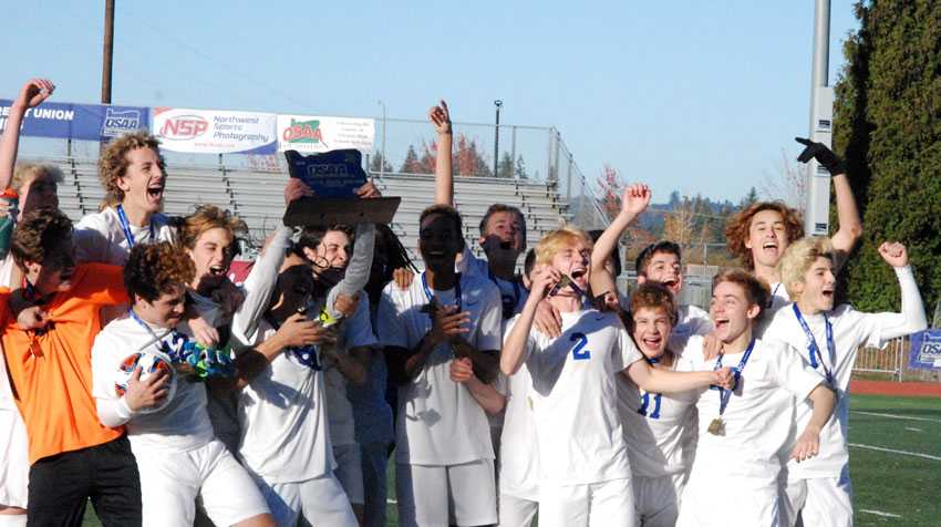 Hansen Lian holds the OSAA championship trophy aloft as his Catlin Gabel teammates celebrate the 3A/2A/1A boys soccer title