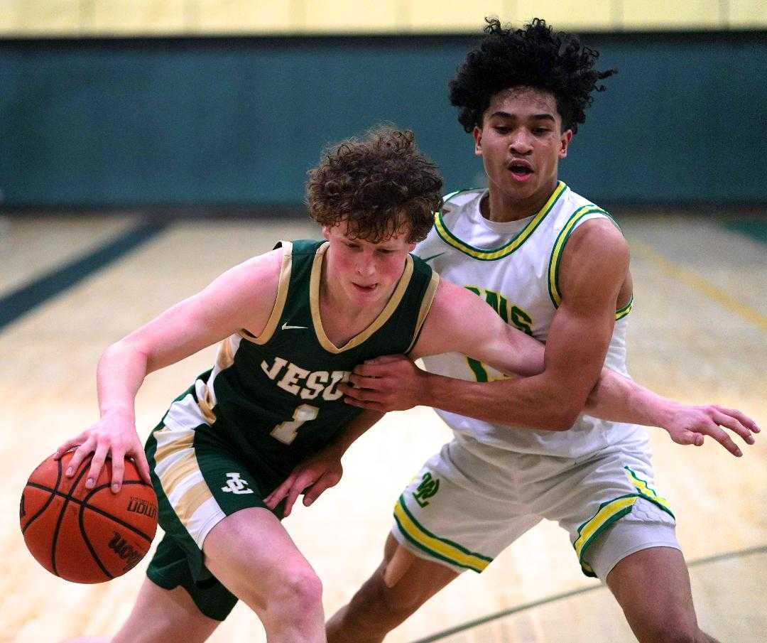 Jesuit's Pat Kilfoil (1) drives against the defense of West Linn's Pat Viavla Jr. on Tuesday night. (Photo by Jon Olson)