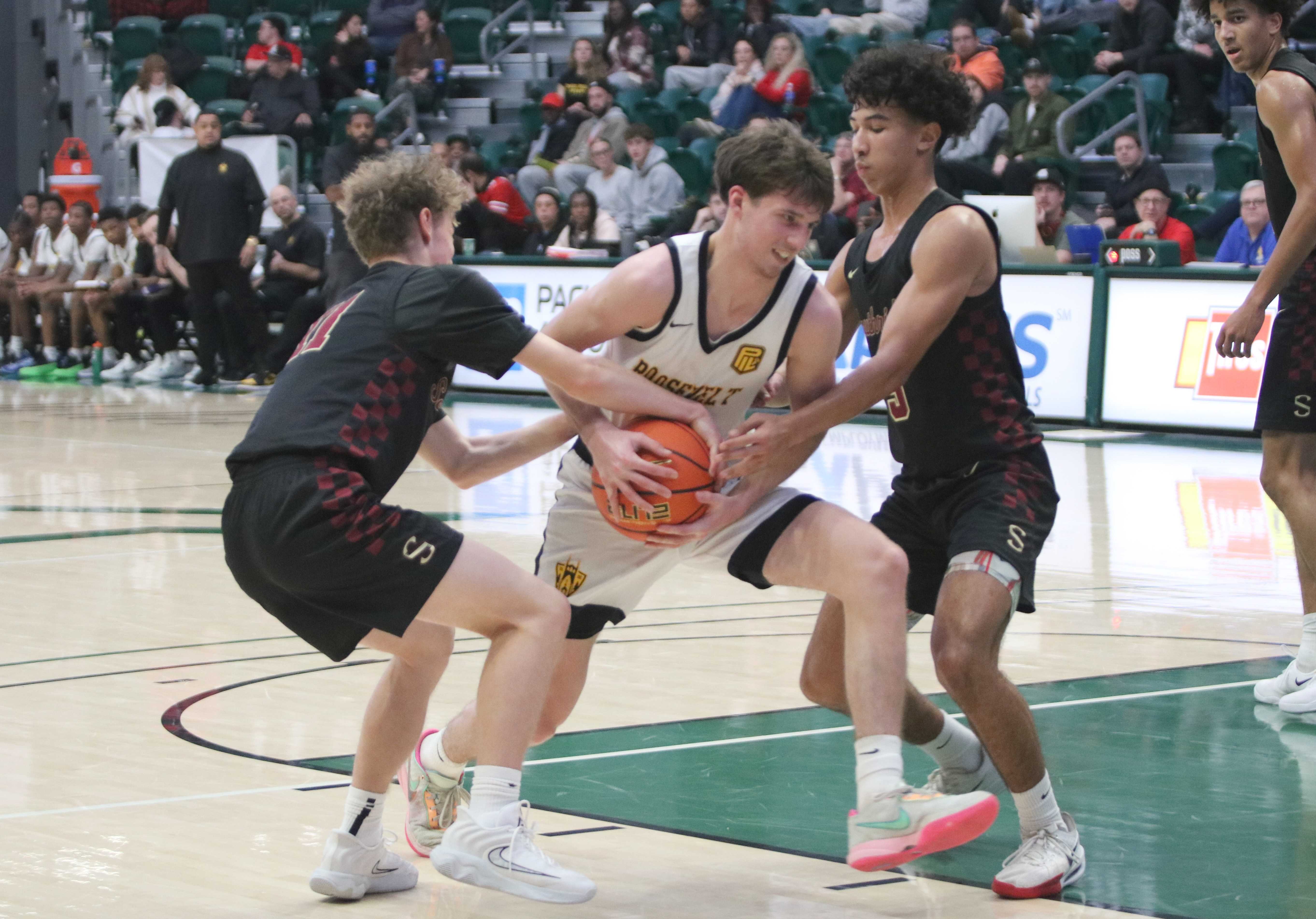 Roosevelt's Owen Nathan tries to split Southridge defenders Julius Vesel (11) and Elijah Thompson during Thursday's LSI opener.