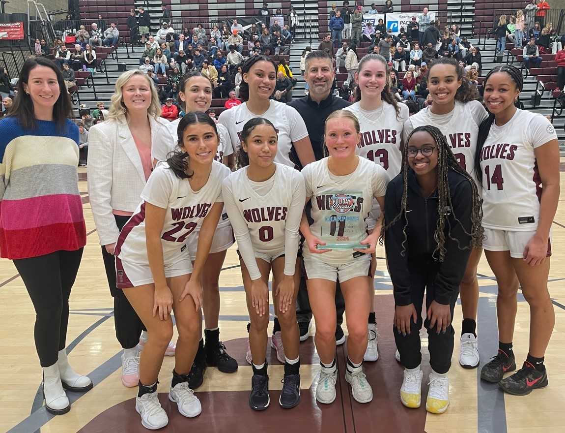 Tualatin's girls basketball team poses with the Platinum bracket trophy after beating Benson on Monday at Franklin High School.