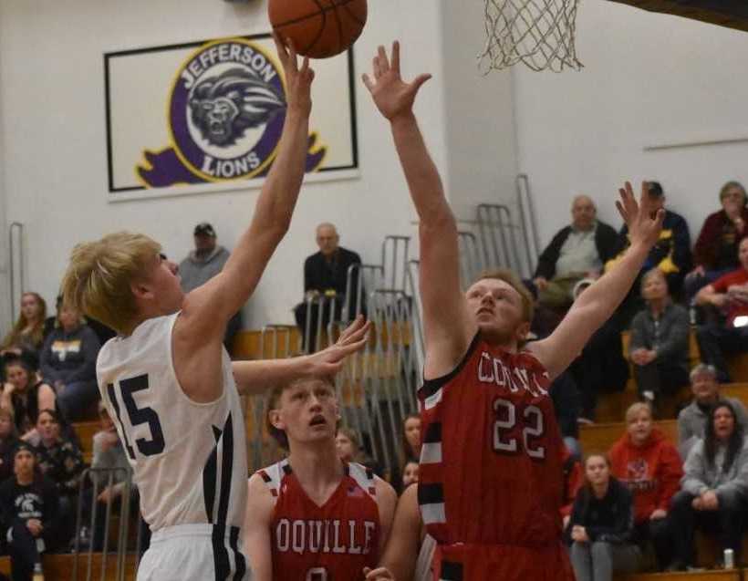 Sheridan's Trevor Lambert (15) drives against Coquille's Ean Smith. (Photo by Jeremy McDonald)