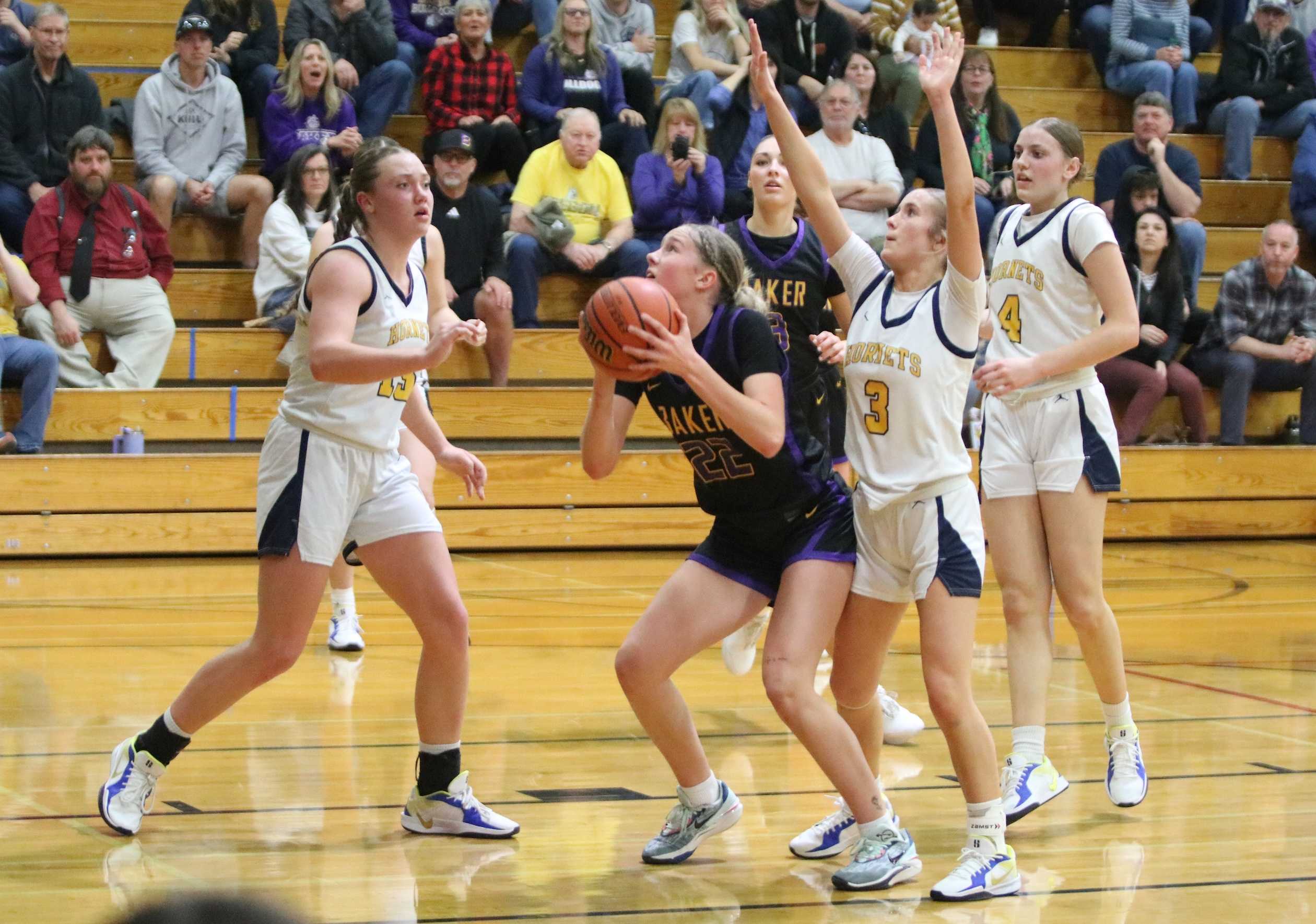 Baker's Molly Rasmussen (22) draws pressure from Henley's Makayla Schroeder (15) and Prestyn Schade (3) on Thursday.