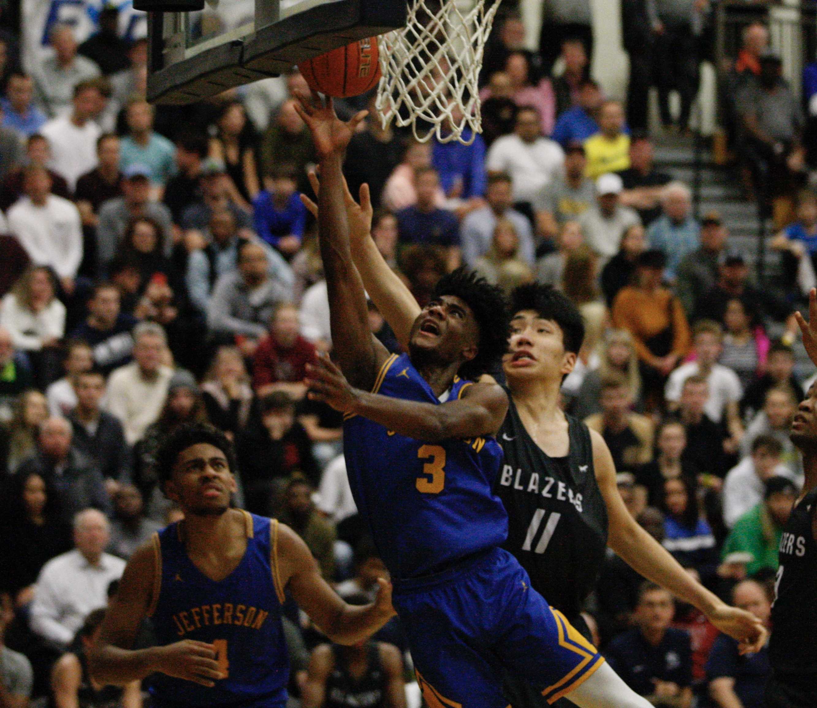Jefferson's 6-4 Jalen Brown slashes past 7-2 Jia-Hao Yu of Sierra Canyon on his way to a layup. (Photo by Norm Maves Jr.)