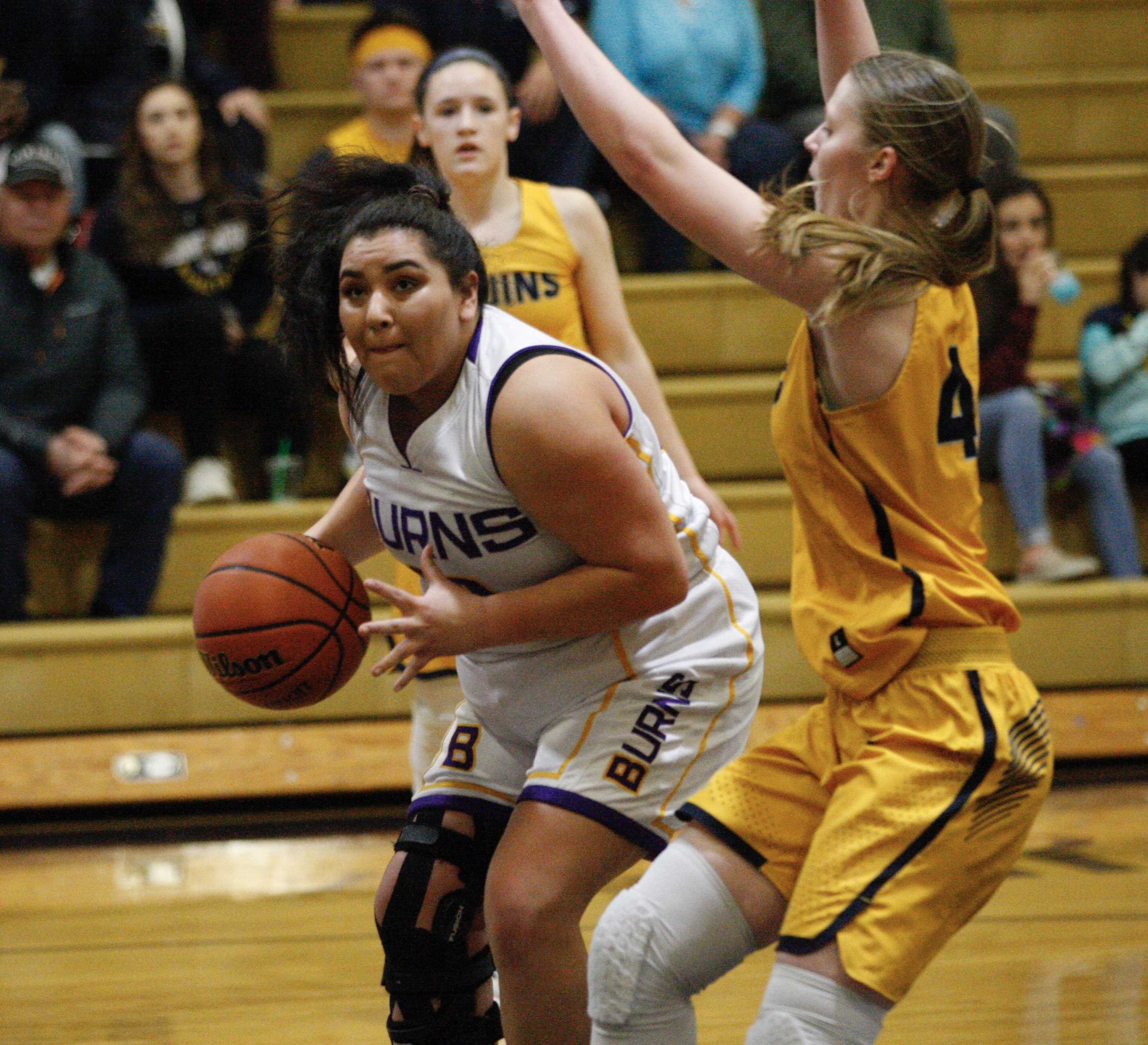 Burns forward Maliah Skunkcap muscles past the defense of Brookings-Harbor's Chloe McCrae. (Photo by Norm Maves. Jr.)