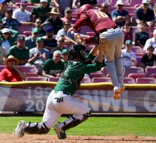 Central’s Mason Smith attempts to score by jumping over Jesuit catcher Joe Angeli