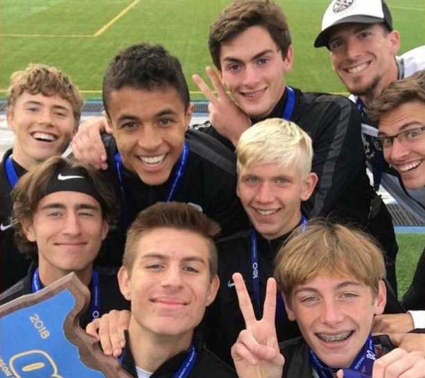 Crater's boys cross country team celebrates its 5A three-peat last year.